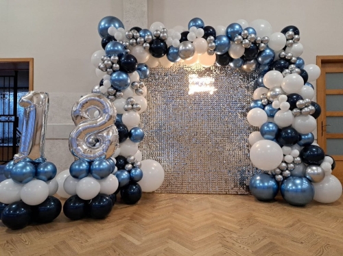 Ścianka balonowa kwadrat na stelażu 2x2 m z cekinami srebrnymi, girlanda niebiesko-czarno-srebrna pełna, mini słupy i cyfry foliowe 18. Montaż dekoracji Tychy.