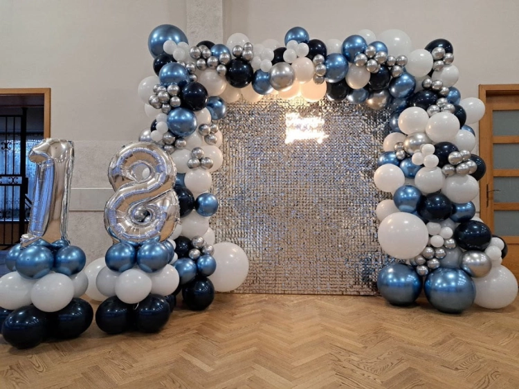 Ścianka balonowa kwadrat na stelażu 2x2 m z cekinami srebrnymi, girlanda niebiesko-czarno-srebrna pełna, mini słupy i cyfry foliowe 18. Montaż dekoracji Tychy.