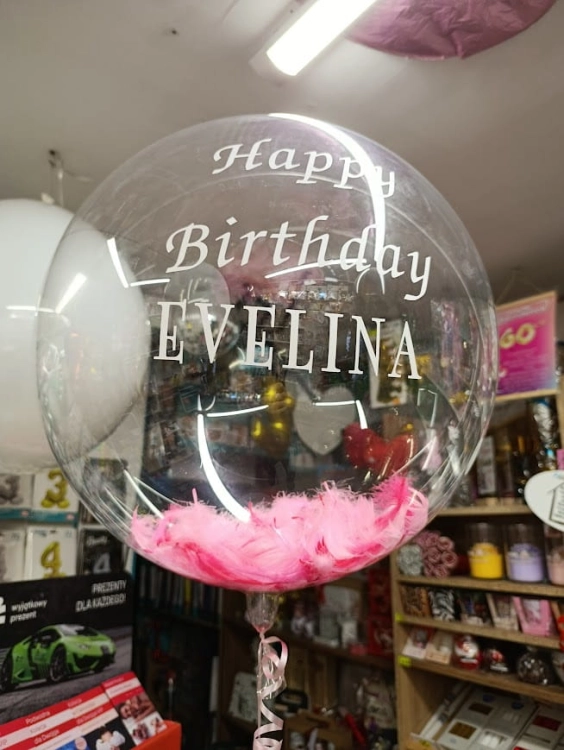 Przezroczysty balon Aqua Bubble z różówymi piórkami i białym  napisem Happy Birthday, realizacja Tychy.