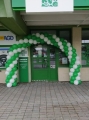 Brama balonowa czerwono biała przed sklepem Apteka, łuk z balonów na otwarcie, dekoracja wejścia w pasażu handlowym.